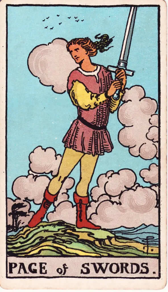 Illustration du Valet d’Épées du tarot Rider Waite : un jeune personnage tient une épée dressée et regarde de côté, debout sur une colline balayée par le vent, sous un ciel nuageux.