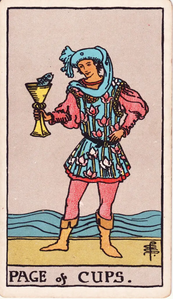 Illustration du Valet de Coupes du tarot Rider Waite : un jeune homme tient une coupe d’où émerge un poisson, debout en bord de mer, vêtu d’un habit coloré et artistique.
