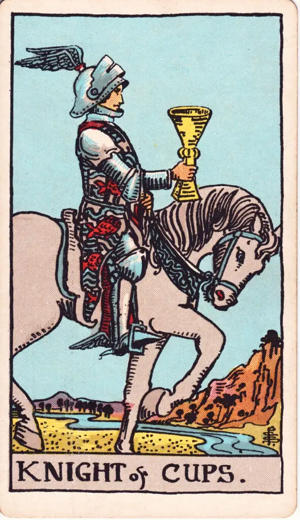 Illustration du Cavalier de Coupes du tarot Rider Waite : un chevalier en armure avance sur un cheval blanc, tenant une coupe devant lui, dans un paysage paisible de collines et de rivière.