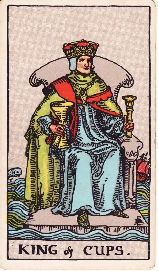Illustration du Roi de Coupes du tarot Rider Waite : un roi est assis sur un trône flottant au milieu de l’eau, tenant une coupe et un sceptre, entouré de vagues et d’un poisson sautant.