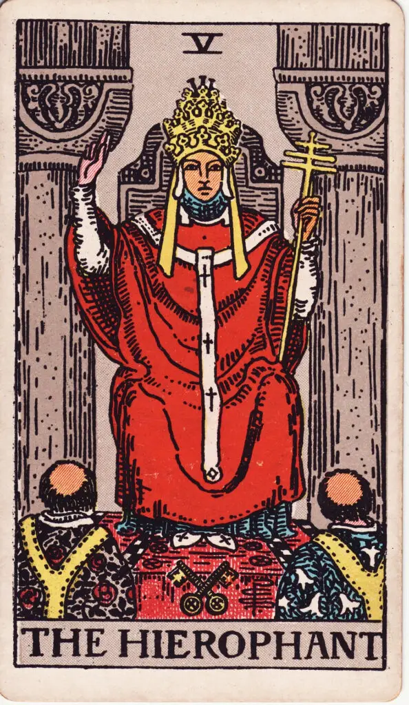 Carte du Pape dans le tarot Rider-Waite : un homme en habits religieux assis entre deux colonnes, bénissant deux disciples, tenant une triple croix. Illustration de 1909 par Pamela Colman Smith.