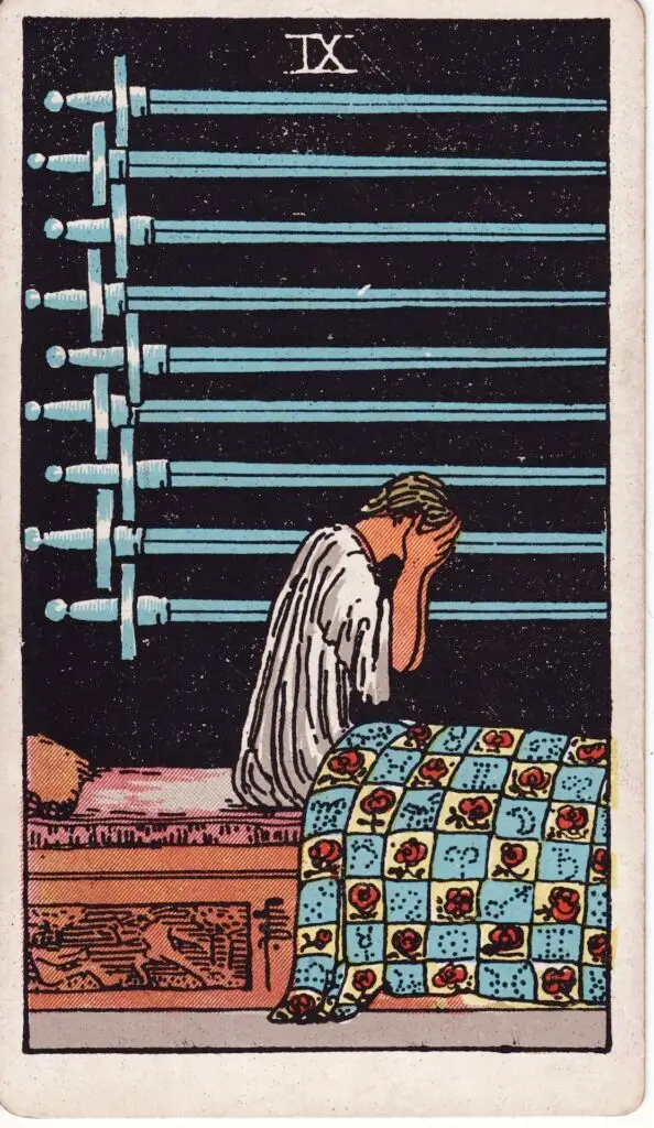 Illustration du Neuf d’Épées du tarot Rider Waite : une femme est assise dans son lit, les mains sur le visage, devant un mur sombre où sont alignées neuf épées.