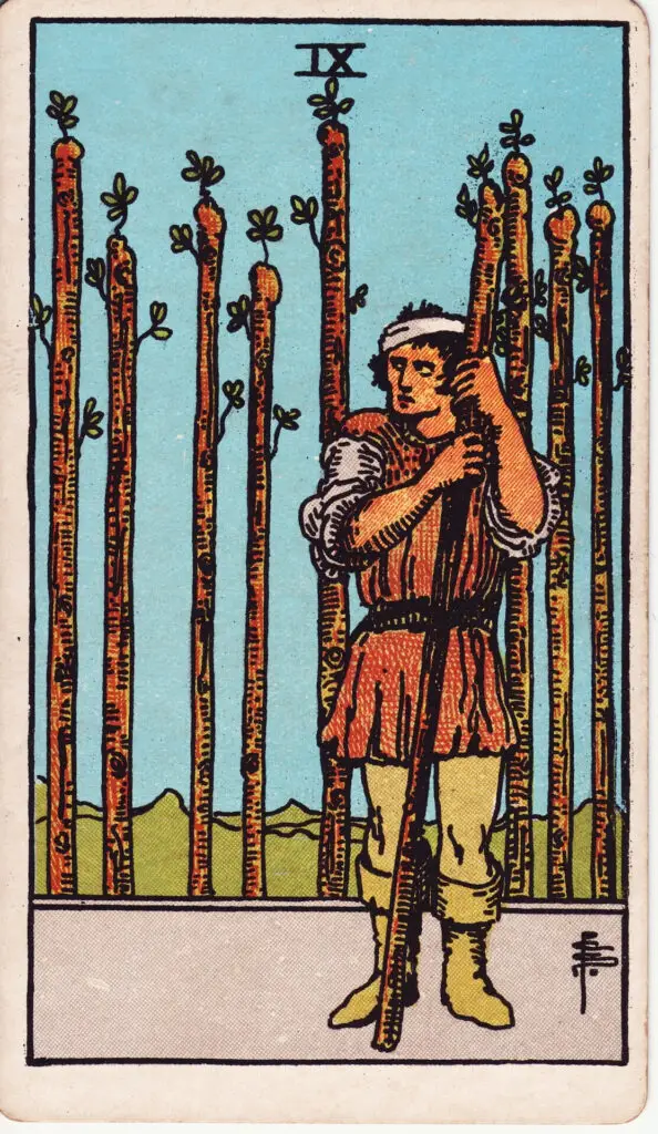 Illustration du Neuf de Bâtons du tarot Rider-Waite : un personnage blessé se tient debout, adossé à un bâton, observant prudemment autour de lui, prêt à se défendre, entouré de huit autres bâtons.